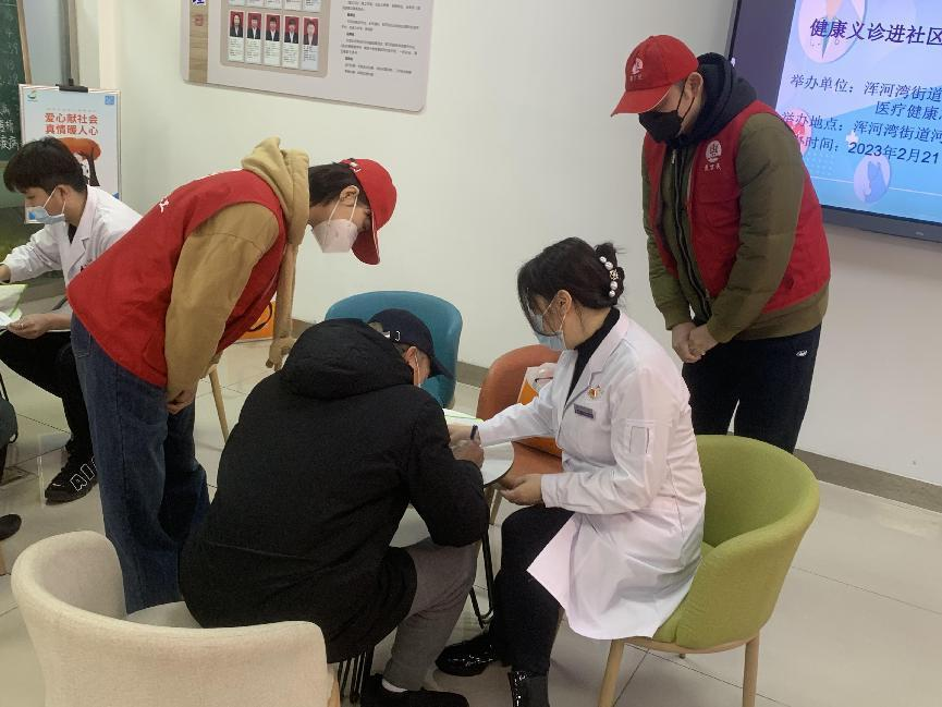 沈阳市第六人民医院的大夫(中间白衣服)在社区开展义诊,社工站志愿者全程服务居民就诊.png